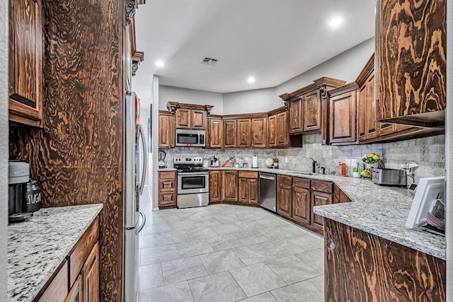 1321 Pine Ave, Midland, TX 79705 - kitchen featuring stainless steel appliances, tasteful backsplash, light stone counters, and recessed lighting