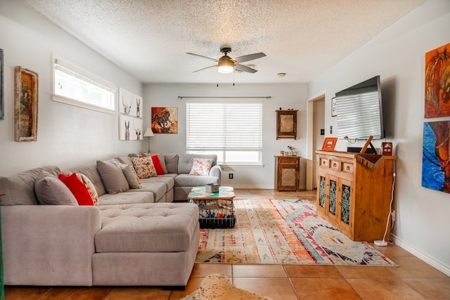 tiled living room with ceiling fan and a textured ceiling