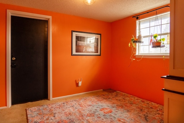 carpeted spare room featuring a textured ceiling