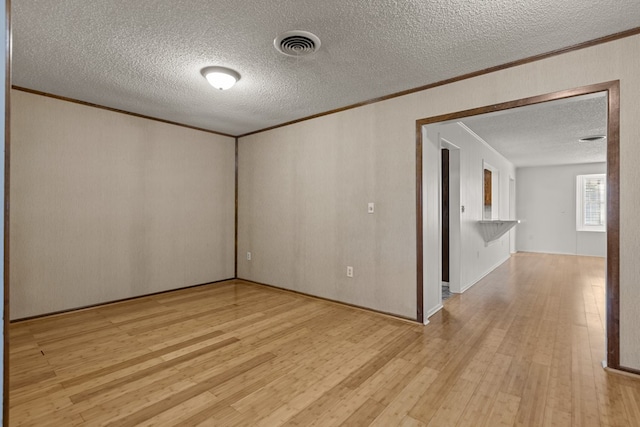 2826 Beechwood St, Odessa, TX 79761 - spare room featuring ornamental molding, a textured ceiling, and light wood-style flooring