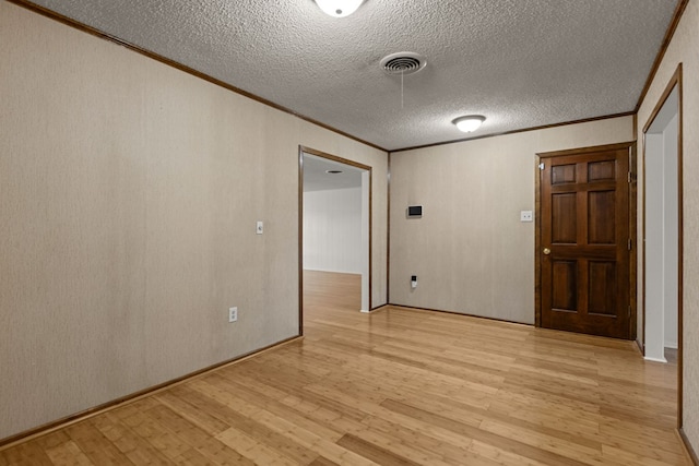 2826 Beechwood St, Odessa, TX 79761 - spare room with crown molding, light wood-style floors, and a textured ceiling