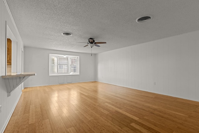 2826 Beechwood St, Odessa, TX 79761 - unfurnished living room featuring light wood-style floors, a ceiling fan, a textured ceiling, and baseboards