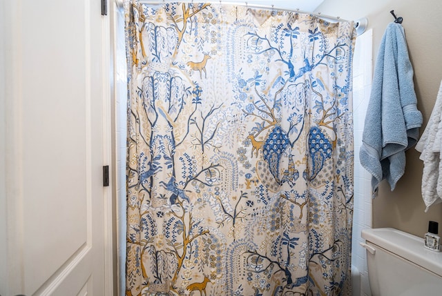 bathroom featuring a shower with curtain and toilet