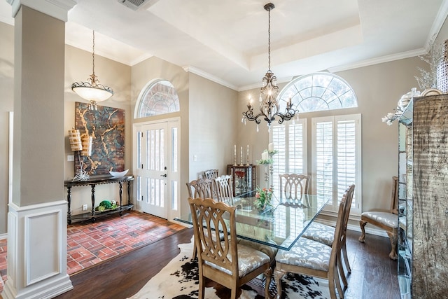 dining room featuring ornamental molding, a tray ceiling, dark hardwood / wood-style floors, and a notable chandelier