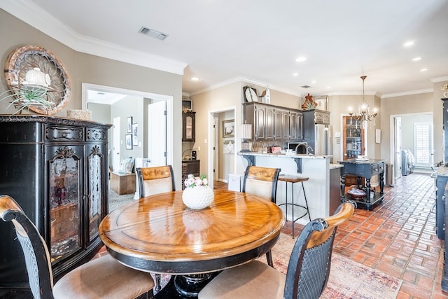 dining room featuring ornamental molding and a notable chandelier