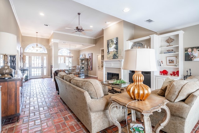 living room with ceiling fan and ornamental molding