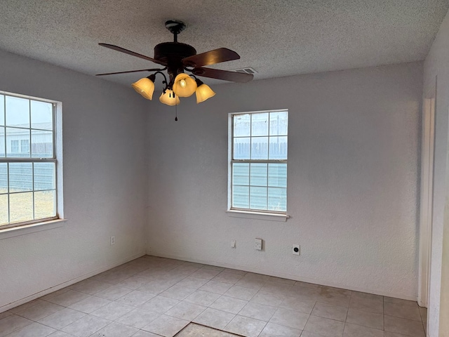 spare room with ceiling fan, a textured ceiling, and a wealth of natural light