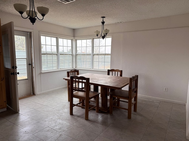 dining area featuring an inviting chandelier, a textured ceiling, and a water view