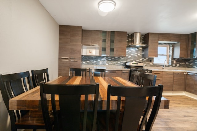 dining space with light hardwood / wood-style flooring and sink