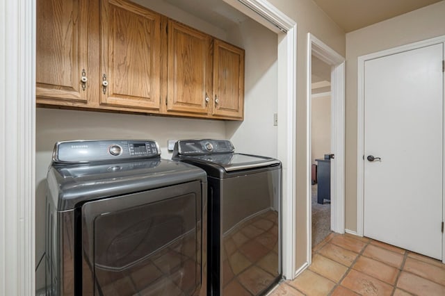 laundry area with cabinet space, light tile patterned flooring, and independent washer and dryer