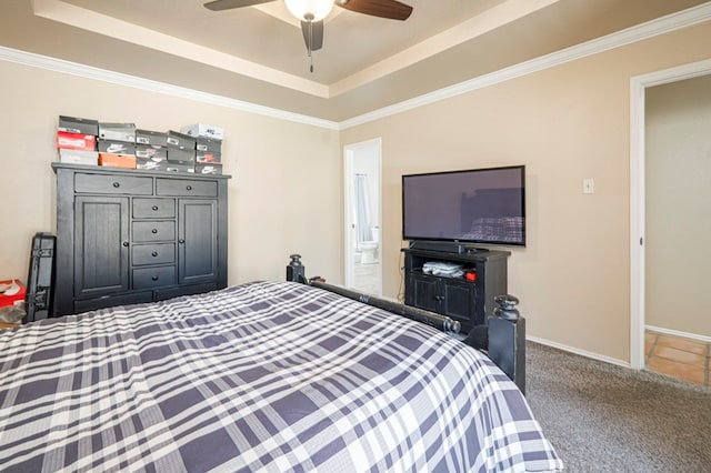 bedroom with ceiling fan, baseboards, a raised ceiling, carpet, and ensuite bath