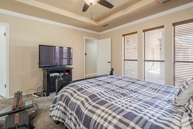 bedroom featuring ceiling fan, carpet floors, visible vents, ornamental molding, and a raised ceiling