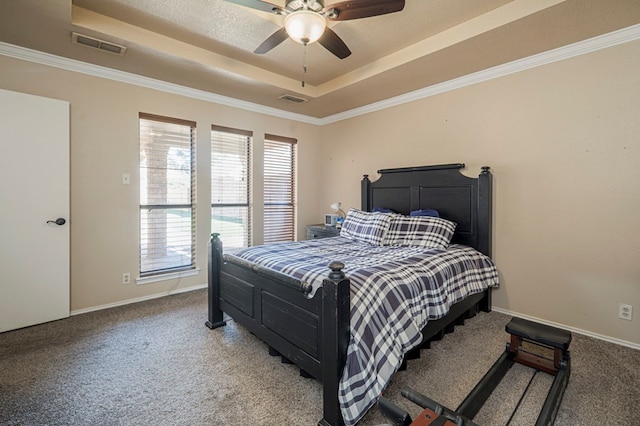 carpeted bedroom featuring ornamental molding, a tray ceiling, visible vents, and baseboards