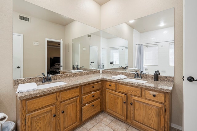 bathroom with double vanity, tile patterned flooring, a sink, and visible vents