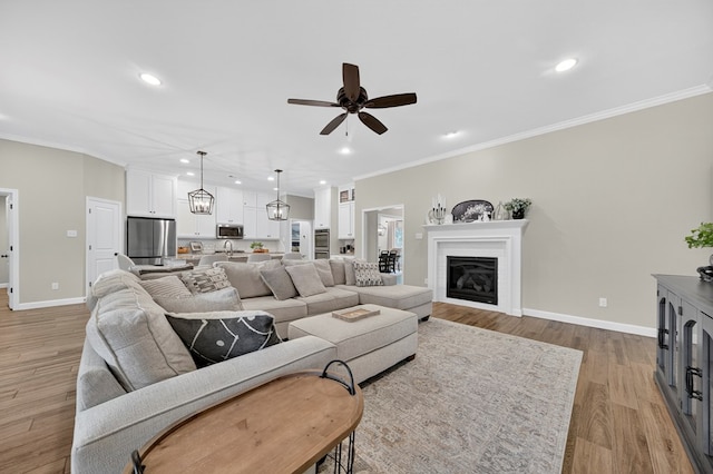 6113 Turtle Creek Rd, Midland, TX 79707 - living area featuring a ceiling fan, light wood-style floors, recessed lighting, crown molding, and a glass covered fireplace