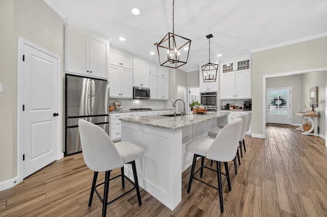 6113 Turtle Creek Rd, Midland, TX 79707 - kitchen with appliances with stainless steel finishes, tasteful backsplash, white cabinets, recessed lighting, and a chandelier