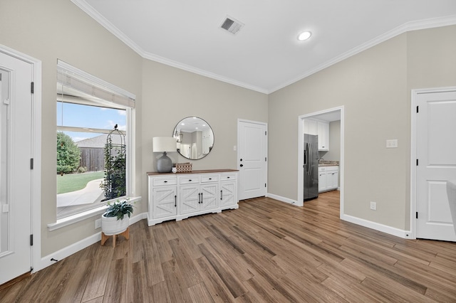 6113 Turtle Creek Rd, Midland, TX 79707 - bedroom featuring ornamental molding, wood finished floors, stainless steel fridge with ice dispenser, and connected bathroom