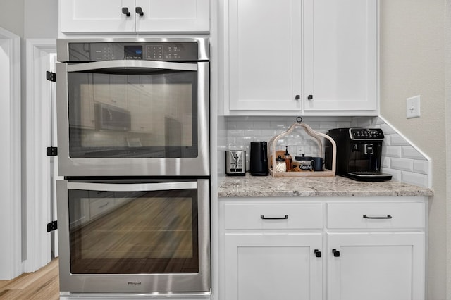 6113 Turtle Creek Rd, Midland, TX 79707 - kitchen with double oven, tasteful backsplash, white cabinetry, and light stone countertops