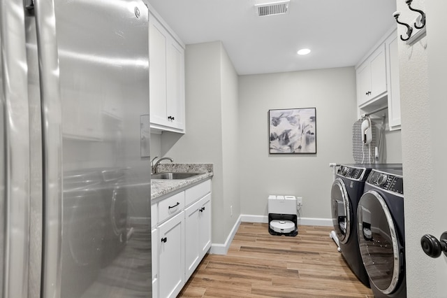 6113 Turtle Creek Rd, Midland, TX 79707 - washroom featuring washer and clothes dryer, light wood-style flooring, cabinet space, and recessed lighting
