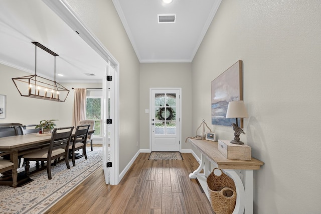 6113 Turtle Creek Rd, Midland, TX 79707 - entrance foyer featuring hardwood / wood-style flooring, ornamental molding, and a chandelier