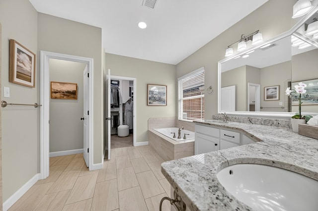 6113 Turtle Creek Rd, Midland, TX 79707 - bathroom with vanity, a garden tub, a spacious closet, and recessed lighting