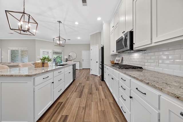 6113 Turtle Creek Rd, Midland, TX 79707 - kitchen with recessed lighting, crown molding, white cabinetry, decorative backsplash, and wood finished floors