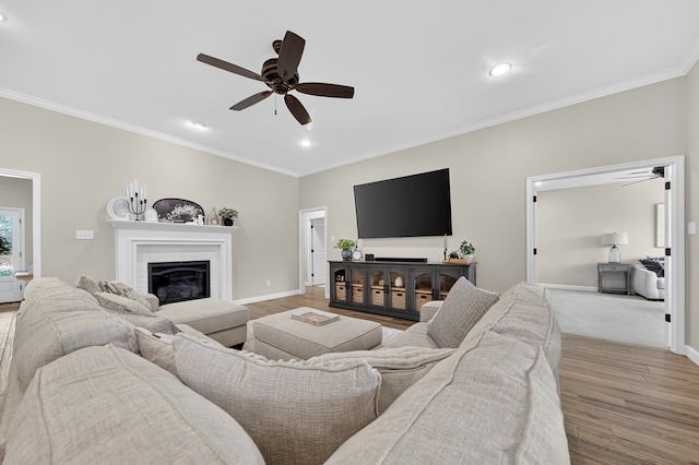 6113 Turtle Creek Rd, Midland, TX 79707 - living area featuring a ceiling fan, ornamental molding, wood finished floors, a glass covered fireplace, and recessed lighting