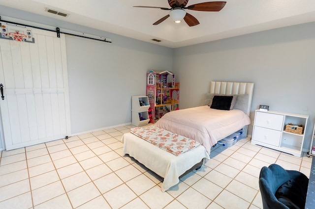 10905 E County Rd 107, Midland, TX 79706 - bedroom with a barn door, light tile patterned floors, ceiling fan, and baseboards