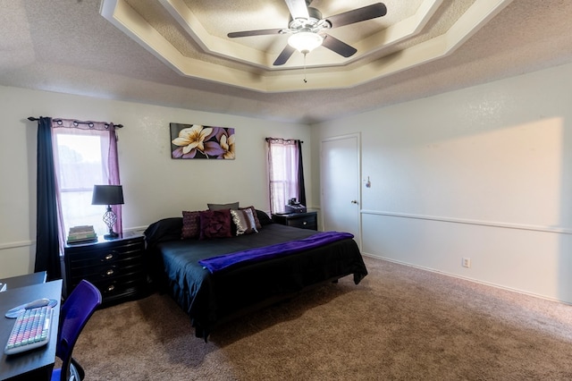 10905 E County Rd 107, Midland, TX 79706 - carpeted bedroom with a raised ceiling, multiple windows, ceiling fan, and a textured ceiling