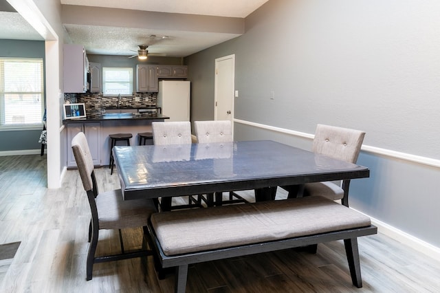 10905 E County Rd 107, Midland, TX 79706 - dining room featuring baseboards, light wood finished floors, and a ceiling fan