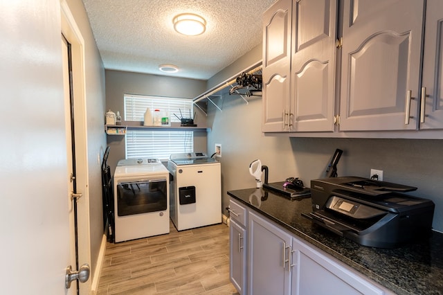 10905 E County Rd 107, Midland, TX 79706 - laundry room featuring washing machine and dryer, light wood-style floors, cabinet space, and a textured ceiling