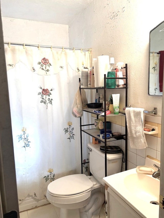 1122 E Cowden Ave, Midland, TX 79701 - bathroom featuring toilet, a textured wall, vanity, and tile patterned floors