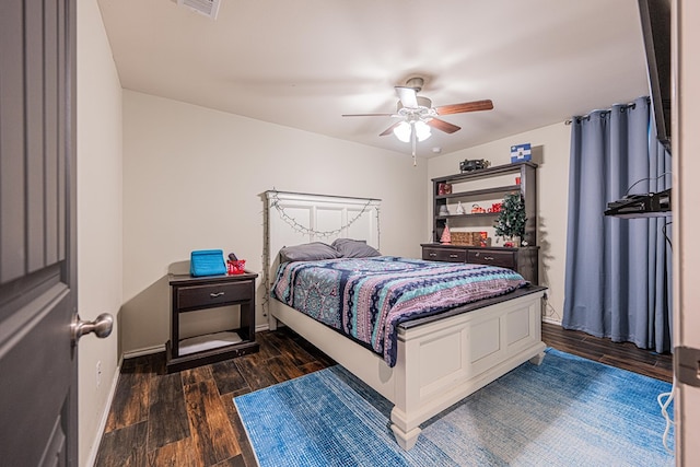 bedroom featuring baseboards, dark wood-type flooring, and ceiling fan