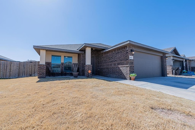 view of front facade with fence, an attached garage, concrete driveway, a front lawn, and brick siding