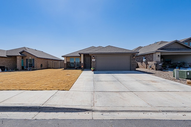 view of front facade with fence, concrete driveway, a front yard, a garage, and brick siding