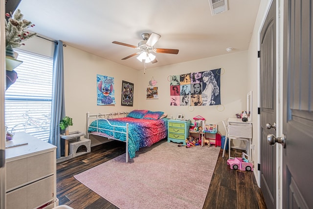 bedroom featuring dark wood-type flooring, multiple windows, a ceiling fan, and visible vents