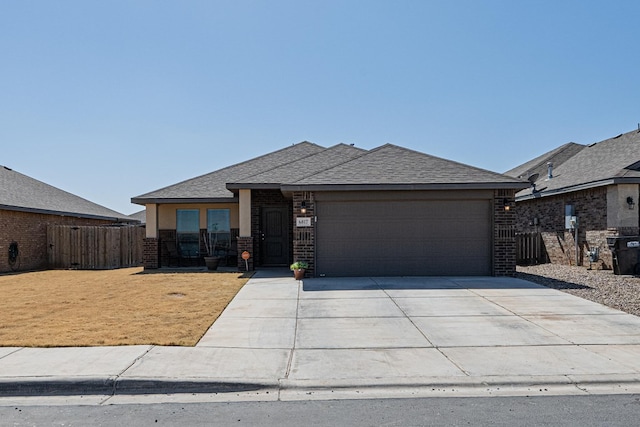 view of front of property with brick siding, driveway, a garage, and fence