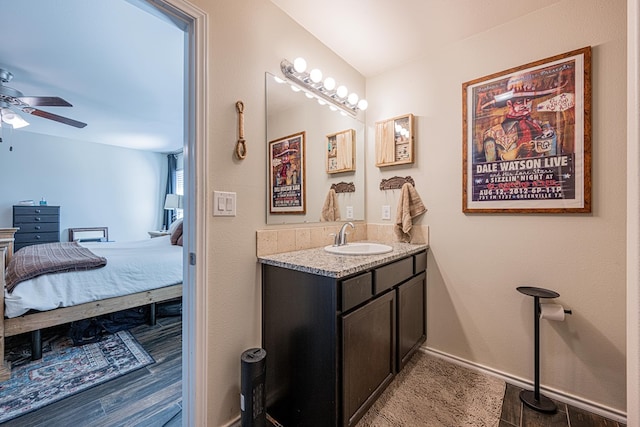 bathroom with vanity, ensuite bath, baseboards, and ceiling fan