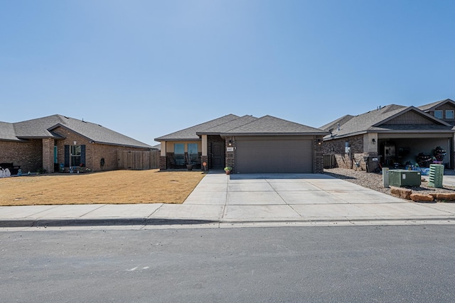 view of front of property featuring a front yard, fence, driveway, a garage, and brick siding