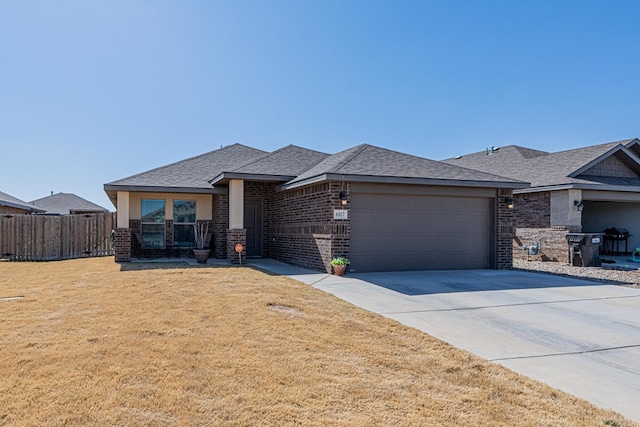 view of front facade with brick siding, driveway, an attached garage, and a front lawn