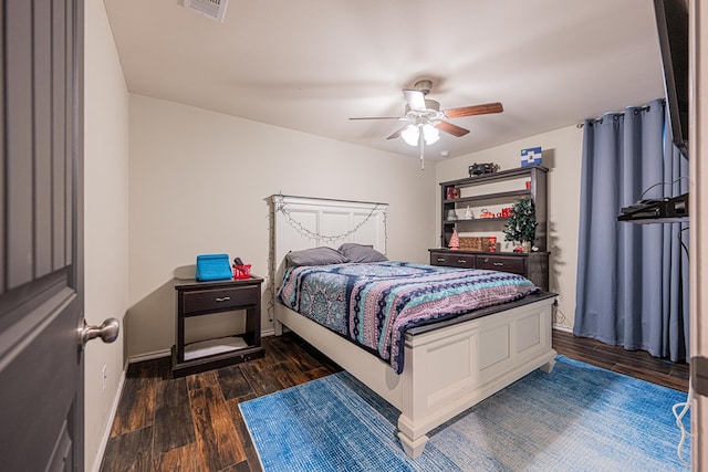 bedroom featuring ceiling fan, visible vents, baseboards, and wood finished floors