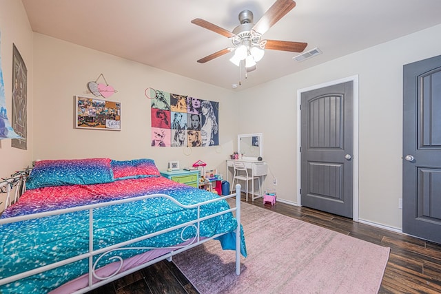 bedroom featuring visible vents, baseboards, dark wood finished floors, and a ceiling fan