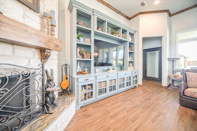 living room with a fireplace, light hardwood / wood-style floors, and ornamental molding