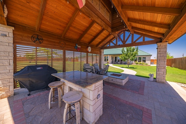 view of patio with a grill, an outdoor bar, and a fire pit