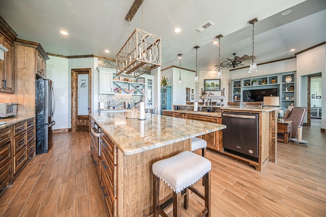 kitchen featuring a breakfast bar, appliances with stainless steel finishes, pendant lighting, and a spacious island