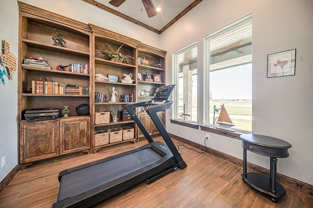 workout area featuring ceiling fan and ornamental molding