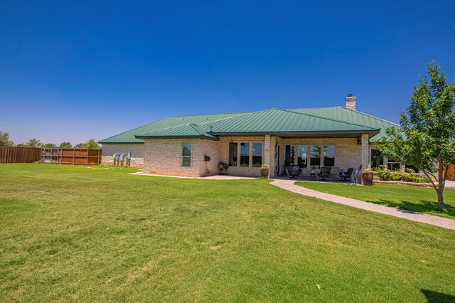 rear view of house featuring a patio area and a yard