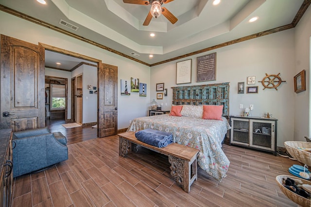 bedroom featuring a tray ceiling, ceiling fan, and ornamental molding