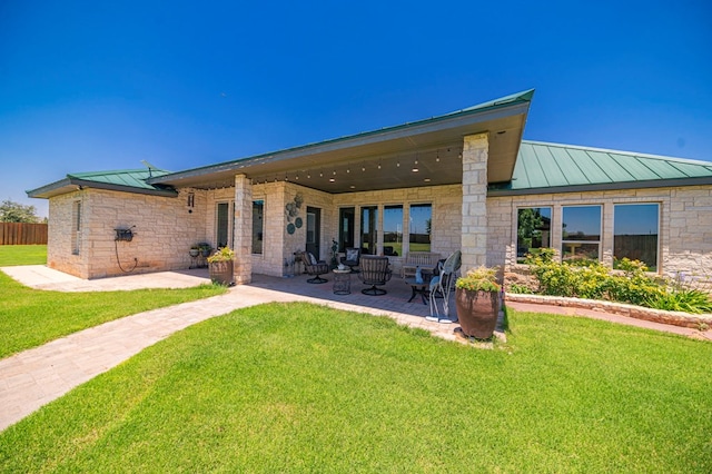 back of property with a patio area and a yard