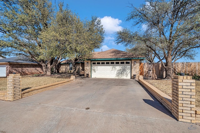 ranch-style home with an attached garage, fence, brick siding, and driveway